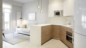 A modern kitchen with a built-in island, stainless steel appliances, and a minimalist design. - Príncipe by FeelFreeRentals (Donostia)