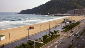 A beachside road with a pedestrian walkway, a lifeguard tower, and a coastal view. - Kantauri by FeelFreeRentals (Donostia)