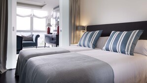 Ein Hotelzimmer mit zwei Betten, einem Schreibtisch und einem Stuhl.