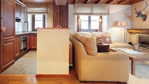 A spacious living area with a sofa, a fireplace, and wooden cabinetry. - Val de Ruda Luxe 65 by FeelFree Rentals (Baqueira)