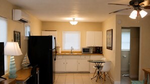 A compact kitchen with a refrigerator, microwave, and sink. - Cozy Gulfport Studio with King Bed + Full Kitchen walkable to Beach Blvd (Gulfport)