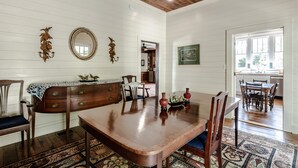 Une salle à manger avec une table en bois, des chaises et un tapis à motifs.