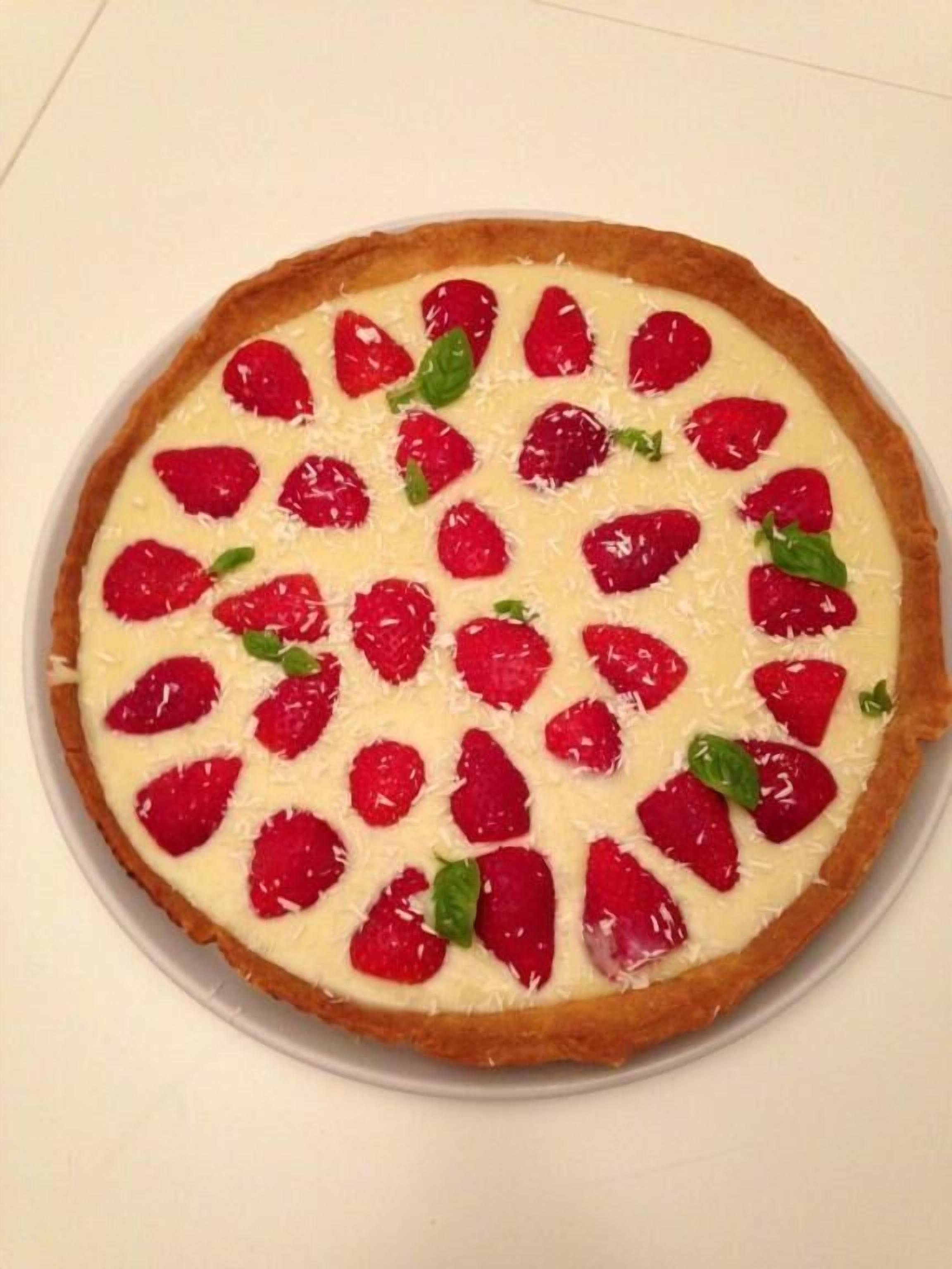 Una tarta redonda cubierta de fresas.