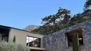 A modern building with a stone facade, large windows, and a well-lit entrance.