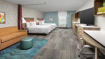 Una habitación de hotel con sofá, dos camas, escritorio y televisor.