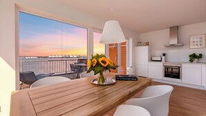 A modern kitchen with white cabinets, a stainless steel oven, and a hanging light fixture. - Baltic Sea vacation in the "Hafenkieker": Fantastic vacation apartment with sauna and sea view! (Olpenitz)