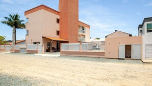 Un edificio moderno con una torre central, varios balcones y un acceso cubierto.
