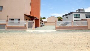 Zona residencial con edificios modernos, entrada protegida y cielo despejado.