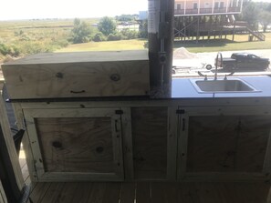 Una cabaña de madera rústica con un lavamanos integrado y un ventanal grande con vistas a un campo de césped.