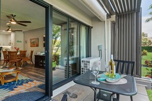 Ein modernes Wohnzimmer mit Glastür, die auf eine Terrassenfläche führt.