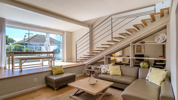 A modern living room with a staircase, a sofa set, a coffee table, and a view of the outside. - Sublime Cottage near Table Mountain and Kloof Street (Tamboerskloof)
