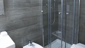 A modern bathroom with a glass-enclosed shower, a bidet, and a toilet. - Rubino Guest House (Rome)