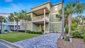 A two-story building with a balcony, surrounded by palm trees and a paved driveway. - Iorana II | A Perfect Autumn Escape! | Game Room | Private Pool | Sleeps 21, Huge Private Master Suite! |  2 PM Check In!  |Gated Community with Amenities (Miramar Beach)