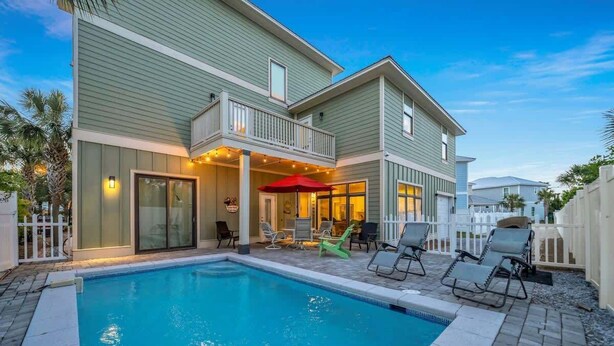 A two-story house with a swimming pool, outdoor seating, and a balcony. - Iorana II | A Perfect Autumn Escape! | Game Room | Private Pool | Sleeps 21, Huge Private Master Suite! |  2 PM Check In!  |Gated Community with Amenities (Miramar Beach)