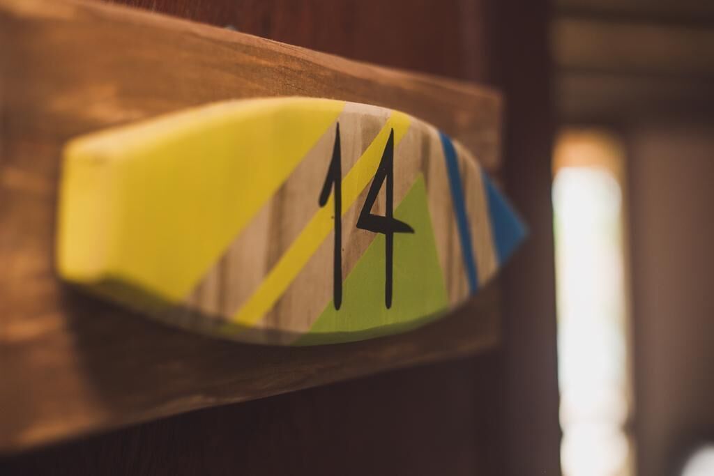 Un gros plan d’une plaque indiquant le numéro de la chambre, fixée sur une porte en bois.