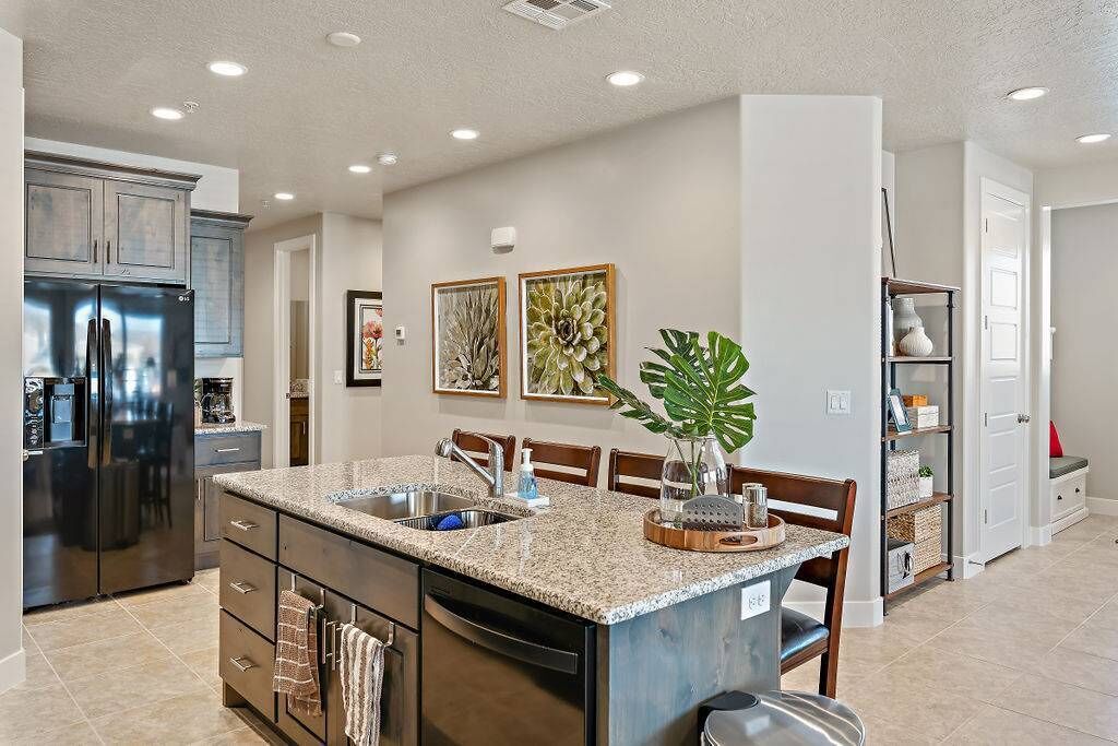 A modern kitchen with granite countertops, stainless steel appliances, and a central island with seating.