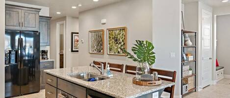 A modern kitchen with granite countertops, stainless steel appliances, and a central island with seating.