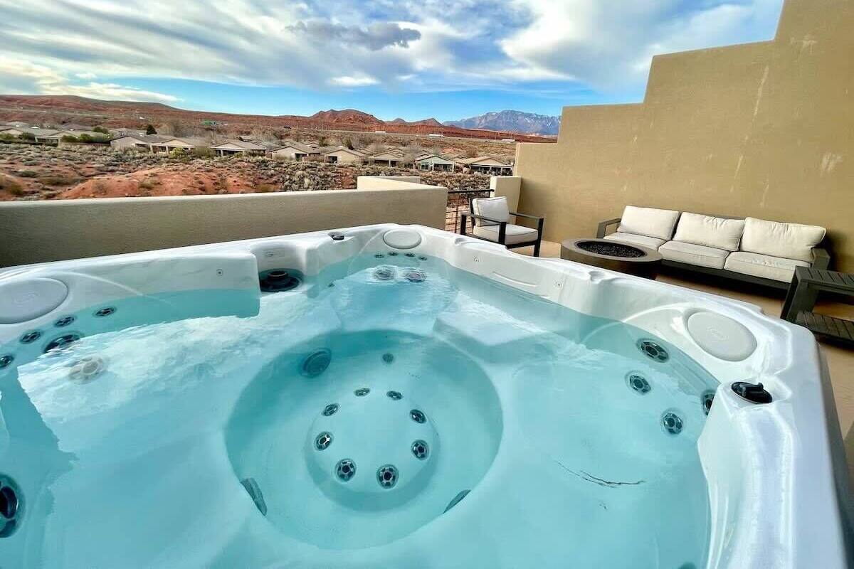 A hot tub with a view of a desert landscape and mountains in the background.