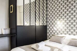 Ein Hotelzimmer mit einem Bett, einem schwarzen Kopfteil, einer Wandverkleidung und einem Spiegel.