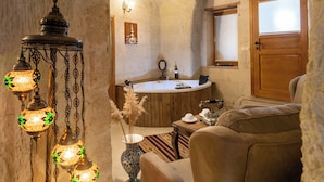 Une pièce chaleureuse avec une baignoire en bois, une porte en bois et un tapis à motifs.