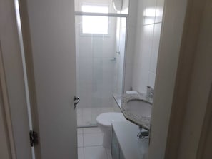 A bathroom with a shower, toilet, and sink.