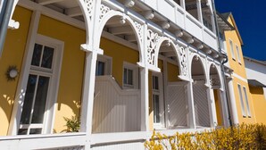 A multi-story building with white balconies and a yellow facade. - Haus Sonne (Sellin)