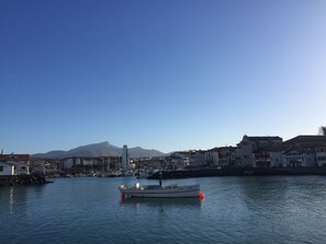 Un bateau était amarré dans une marina, avec des bâtiments et des montagnes en arrière-plan.