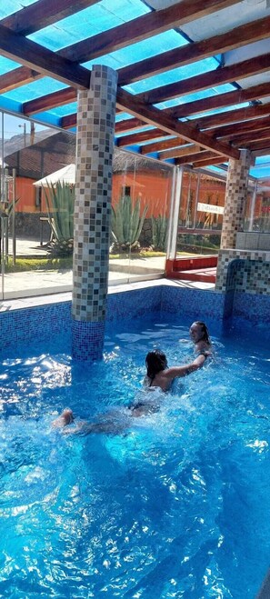 Una piscina techada, sillones reclinables de piscina