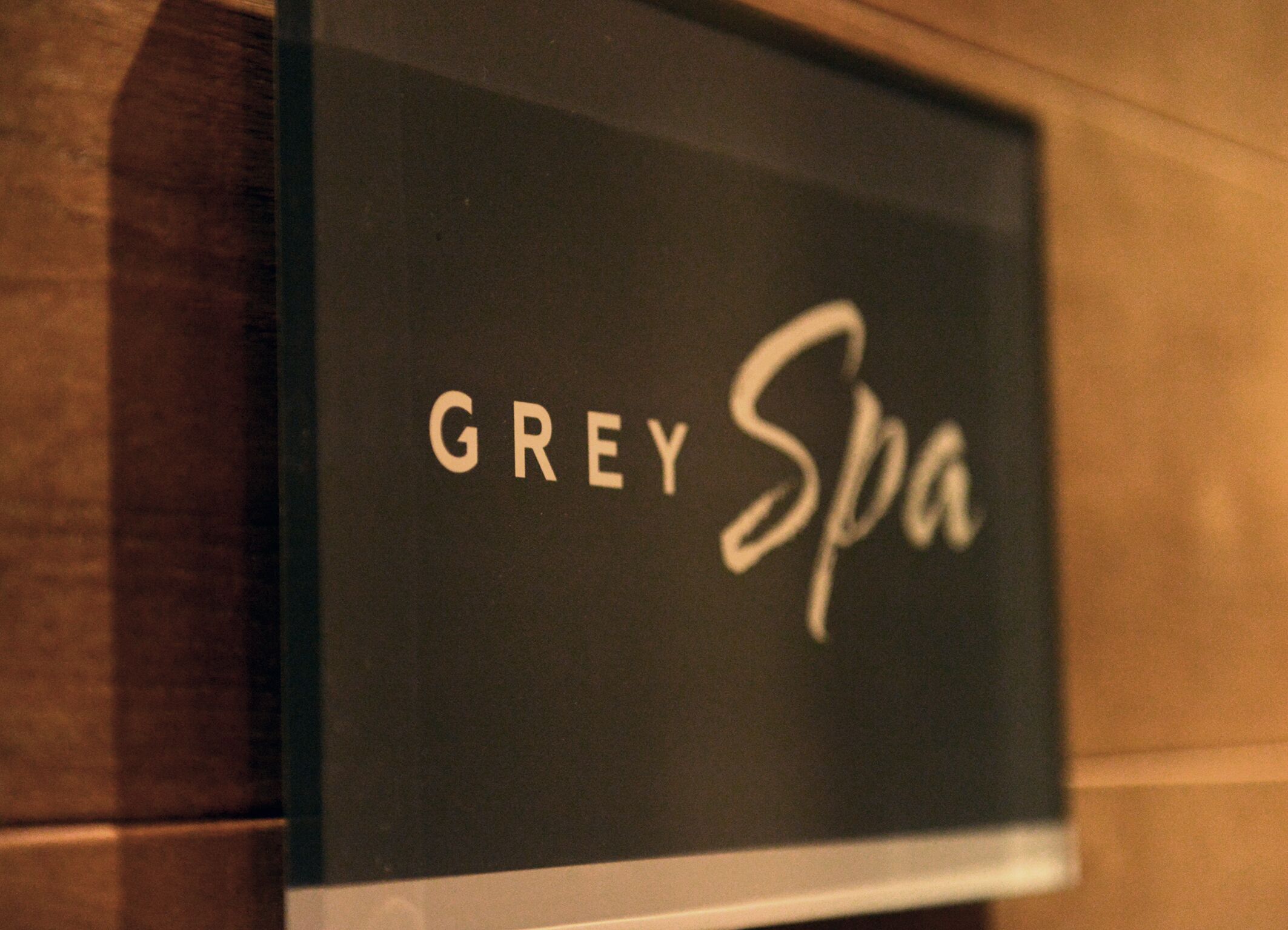 A sign with the words "GREY Spa" on a dark background.