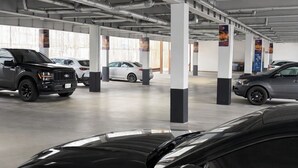 A parking garage with multiple cars, including a black sports car in the foreground. - Cabana Hotel Yankee Stadium (Bronx)