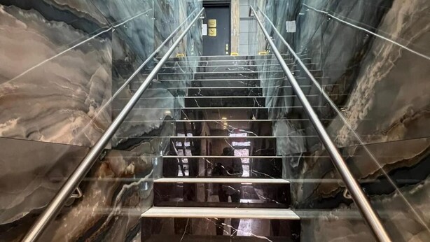 A marble staircase with metal railings leading to an exit door. - Cabana Hotel Yankee Stadium (Bronx)