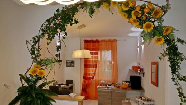 A modern living room with a sofa, a coffee table, and a dining area with a table and chairs. - La Marmifera B&B (Carrara)