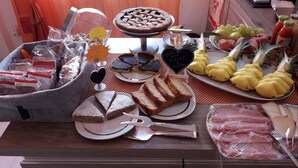 A breakfast buffet with various food items including bread, pastries, fruits, and meats. - La Marmifera B&B (Carrara)