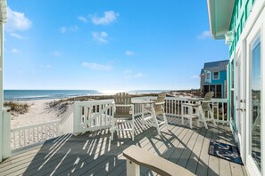 A wooden deck with white railings overlooking a beach. - Recently updated, beautifully furnished gulf front home with decks galore! (Gulf Shores)