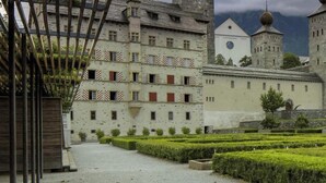 A historic building with a courtyard, stone walls, and a mountain backdrop. - Hotel Stockalperhof (Brig)