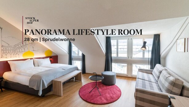 A panoramic lifestyle room with a bed, a small table, a sofa, and large windows. - Hotel Stockalperhof (Brig)