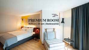 A hotel room with a bed, bedside table, lamp, and a small table with a chair. - Hotel Stockalperhof (Brig)