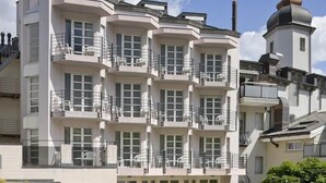 A multi-story building with balconies and a tower with a dome. - Hotel Stockalperhof (Brig)