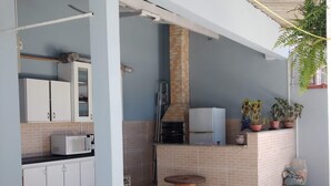 Una cocina con microondas, armarios, chimenea de ladrillo y plantas en macetas.