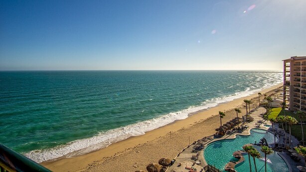 A beach resort with a pool, beach, and ocean view.