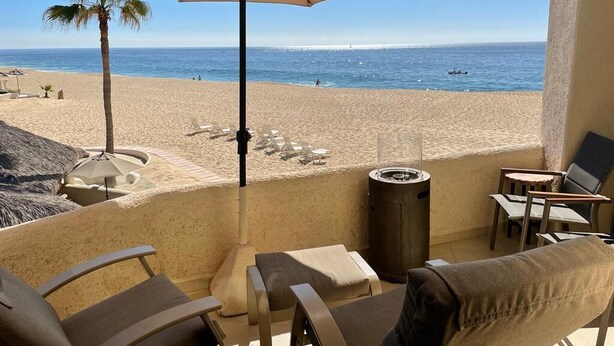 A balcony with a view of the beach, lounge chairs, and a trash can. - Beach front 2 Bedroom 2 Bathroom luxury condo with amazing views.  (Cabo San Lucas)