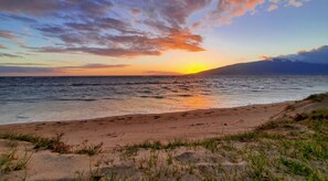 Rannalla, aurinkotuoleja, aurinkovarjoja, rantapyyhkeitä