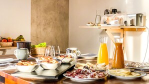 A breakfast buffet with various dishes, a coffee machine, and a fruit basket. - Tenuta Novecento Bio Agriturismo (Agerola)