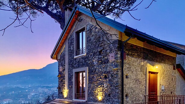 A stone house with a wooden deck and a mountain view. - Tenuta Novecento Bio Agriturismo (Agerola)
