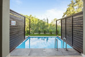 Ein rechteckiger Swimmingpool mit einer Metallleiter, umgeben von einem Holenzaun und einem Schild mit der Aufschrift: kein Schwimmen.