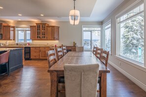 Enjoy meals at the large dining table with ample seating in this well-equipped kitchen.