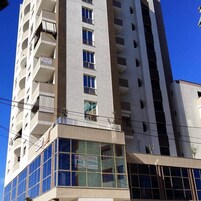 Um edifício alto com várias varandas e grandes janelas.