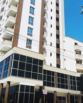 A high-rise building with multiple balconies and a modern architectural design.