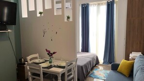 A compact living space with a dining area, a bed, and a sofa. - Rezidenca Shopi Apartments (Elbasan)