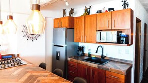 A kitchen with wooden cabinets, a stainless steel refrigerator, a microwave, and a sink. - Boana Torre Malibu #405 , Ocean view, romantic zone (Amapas)